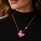 Selunyra pink rose gold butterfly necklace worn over black knit