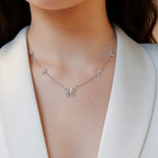 Selunyra Cheer five-butterfly necklace worn with an ivory blazer