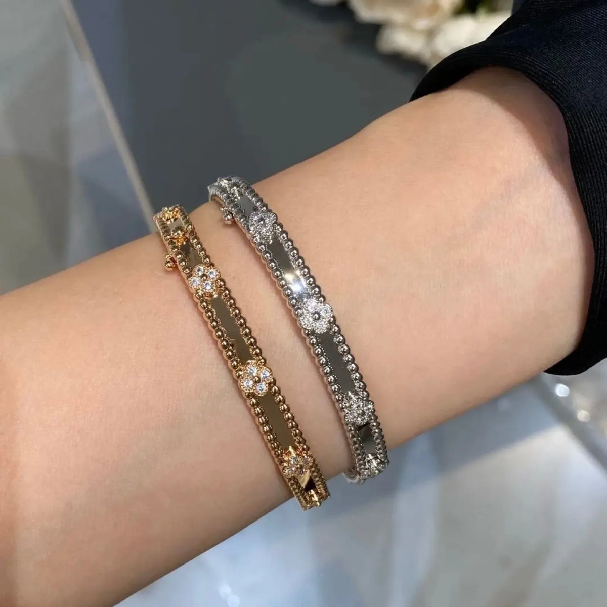 Selunyra clover bracelets in gold and silver worn on wrist