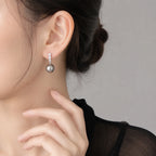 Selunyra graphite diamond pearl drop earring worn with a black blouse