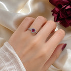 Selunyra red heart halo ring worn on cream satin
