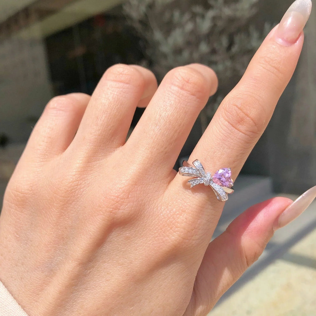 Selunyra pink heart and bow ring worn close-up